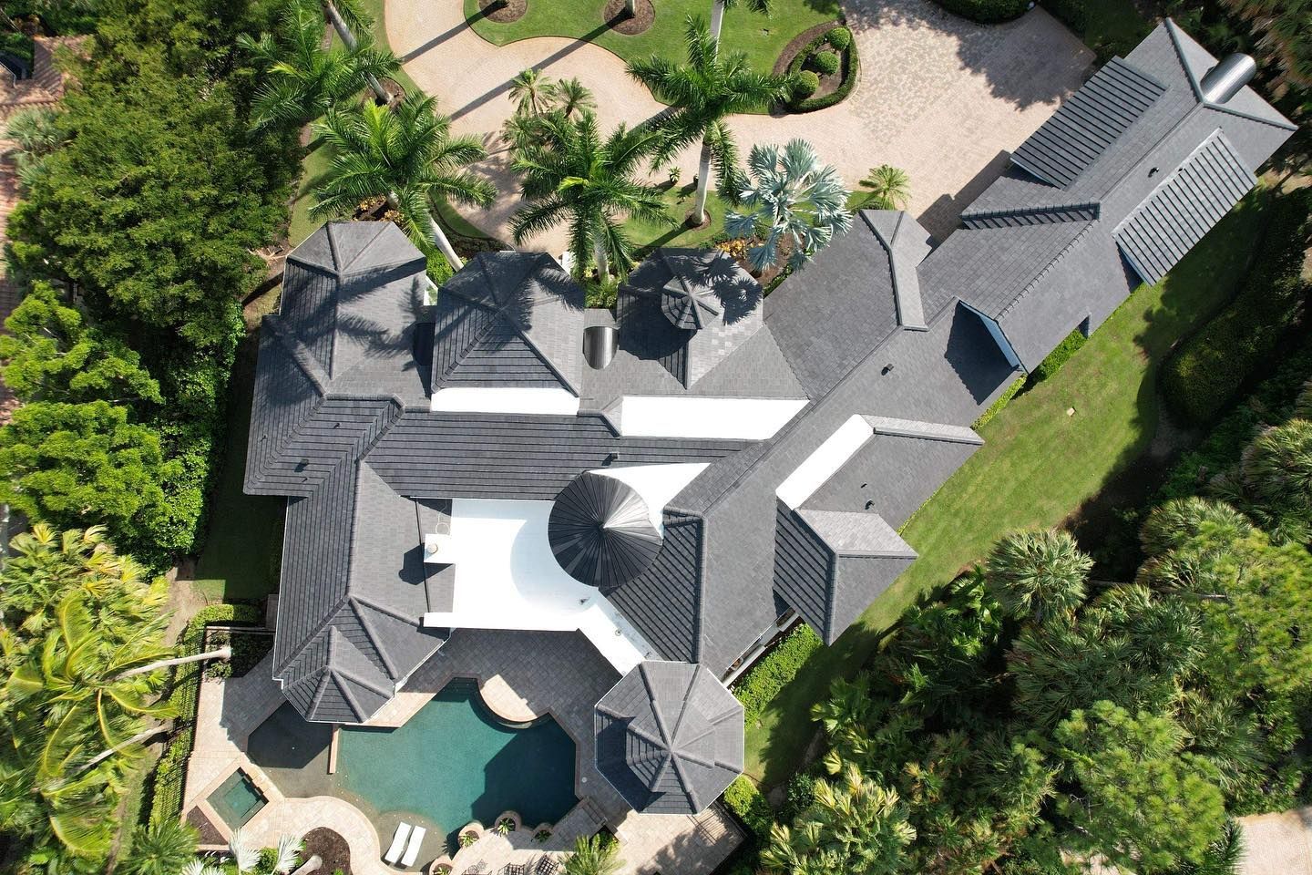 An aerial view of a large house with a pool