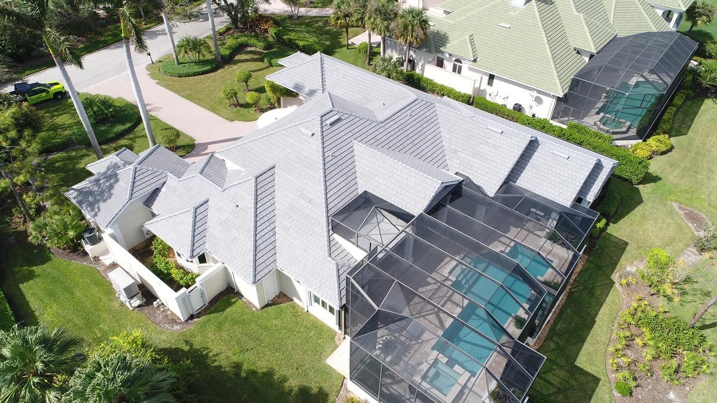 An aerial view of a large house with a pool in the backyard.