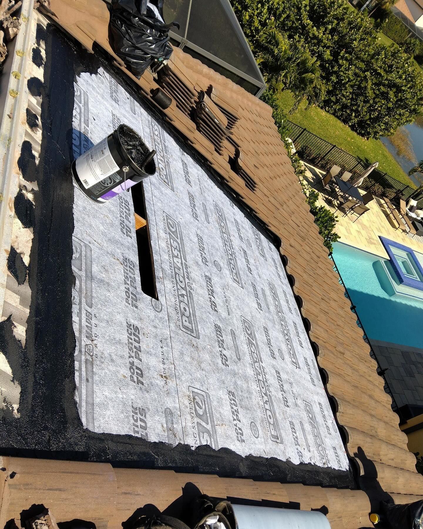 A roof with a hole in it and a pool in the background