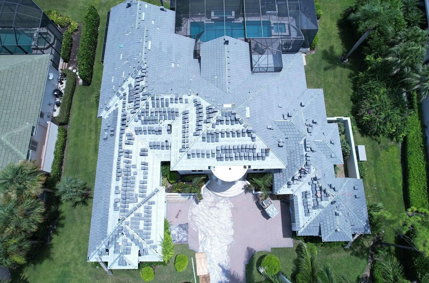 An aerial view of a large house with a pool in the backyard.