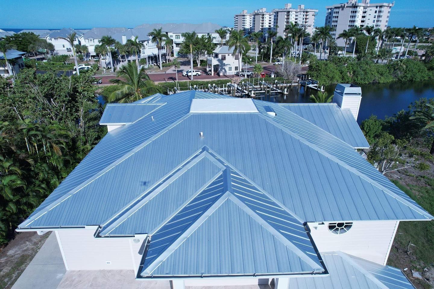 An aerial view of a large house with a blue roof.