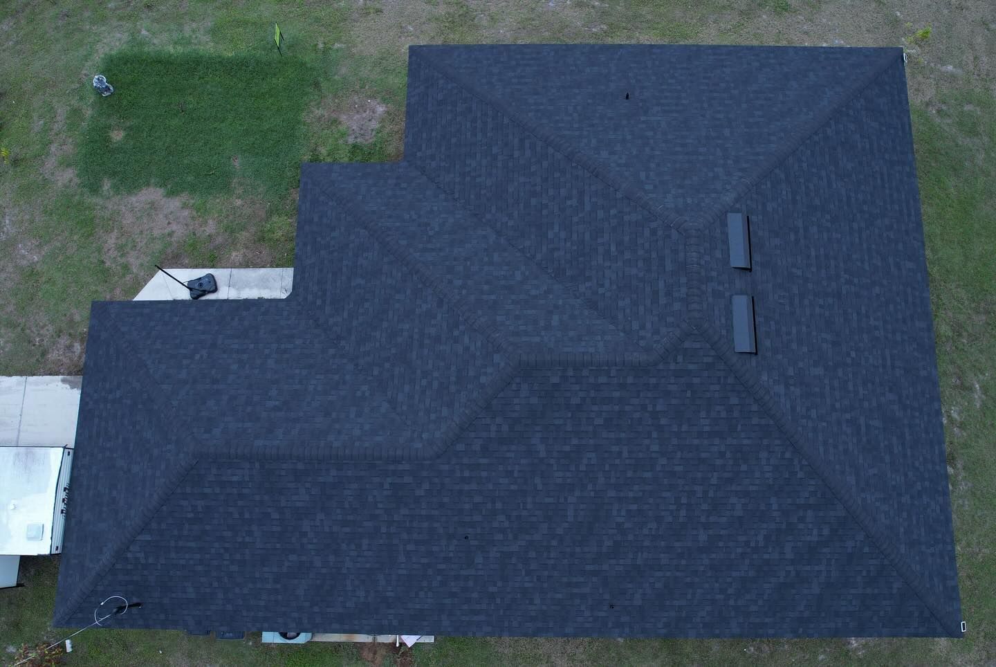 An aerial view of a house with a black roof.