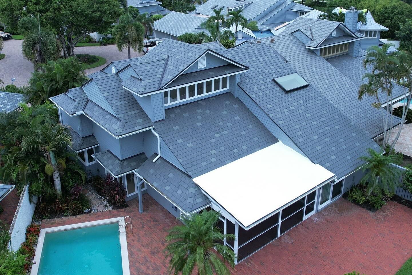 An aerial view of a large house with a pool in the backyard.