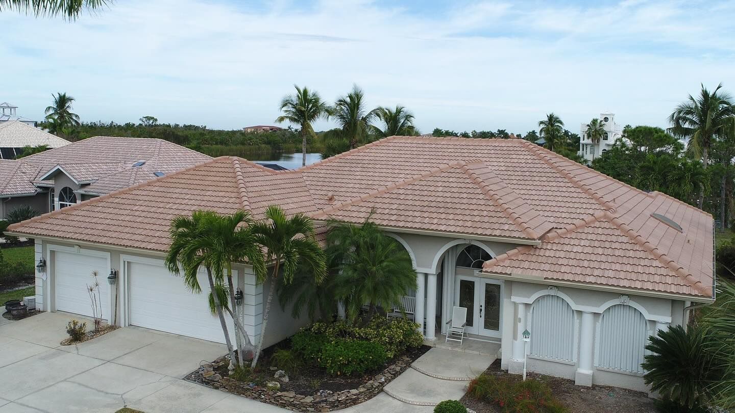 An aerial view of a large white house with a tiled roof