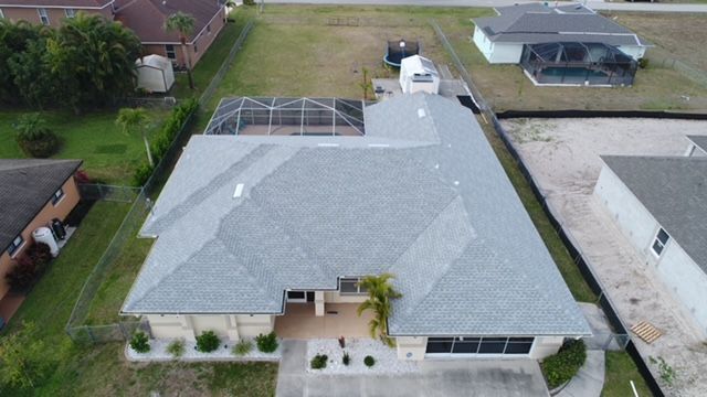 An aerial view of a house with a gray roof
