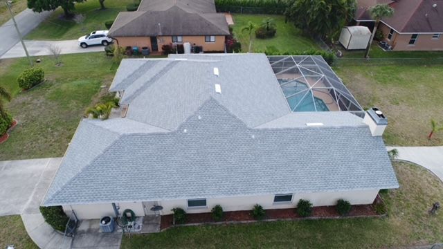 An aerial view of a house with a roof and a pool.
