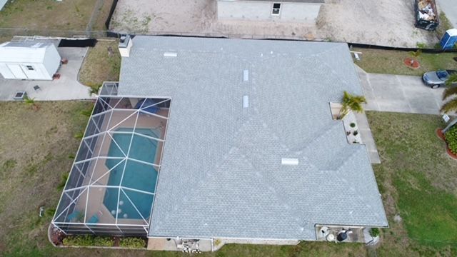 An aerial view of a house with a pool in the backyard.