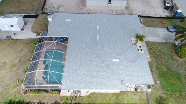 An aerial view of a house with a pool in the backyard.