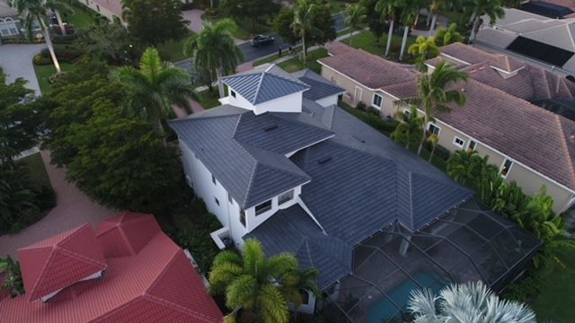 An aerial view of a house with a roof in a residential area.