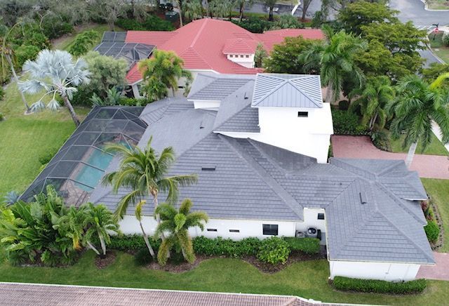An aerial view of a large house with a gray roof
