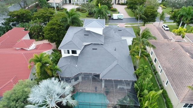 An aerial view of a large house with a pool in a residential area.