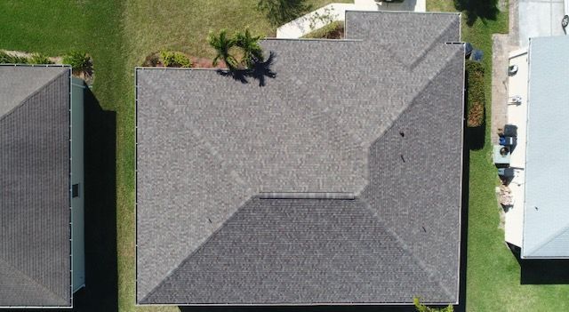 An aerial view of a roof of a house in a residential area.