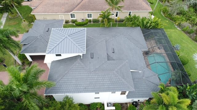 An aerial view of a house with a roof and a pool.