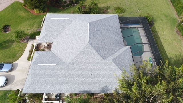 An aerial view of a house with a roof and a pool.