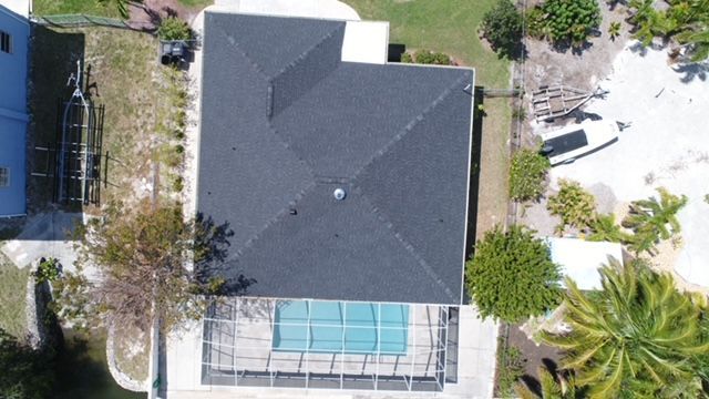 An aerial view of a house with a pool in the backyard.
