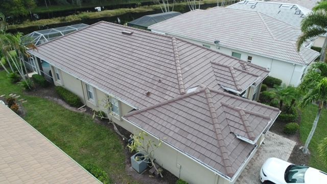 An aerial view of a house with a brown roof and a white truck parked in front of it.
