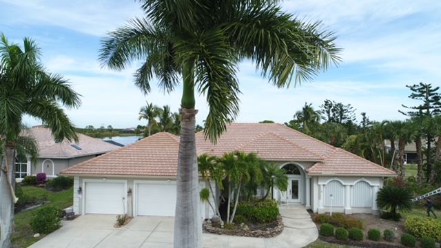 An aerial view of a house with a palm tree in front of it.
