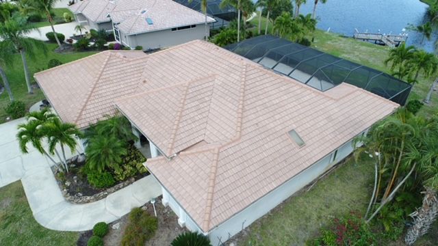 An aerial view of a house with a tiled roof and a pool.