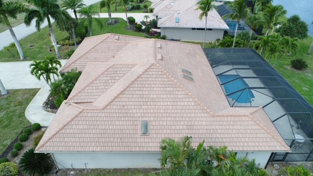 An aerial view of a house with a tiled roof and a pool.