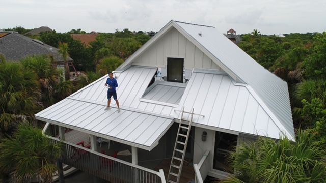 A man is standing on the roof of a house.