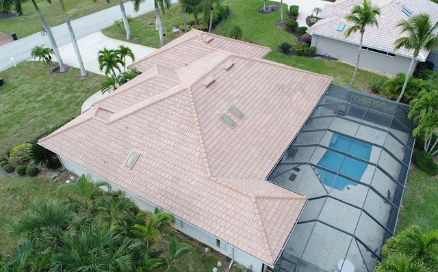 An aerial view of a house with a pool and a roof.