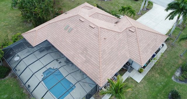 An aerial view of a house with a pool and a screened in porch.