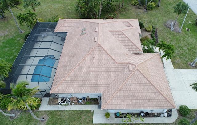 An aerial view of a house with a pool and a tiled roof.