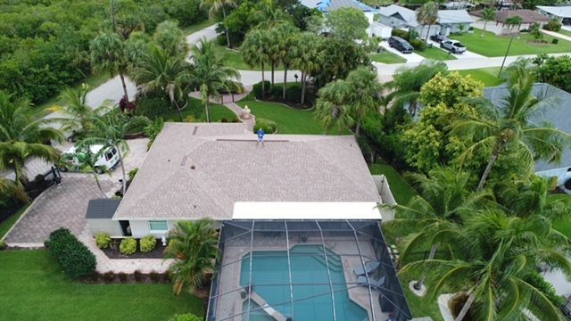 An aerial view of a house with a pool and a roof.