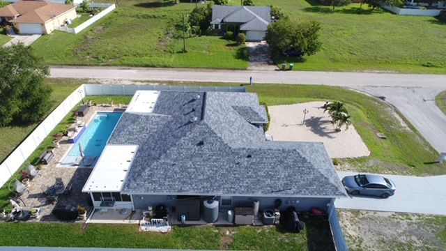 An aerial view of a house with a pool and a car parked in front of it.