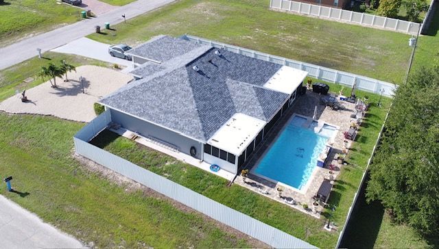 An aerial view of a house with a swimming pool in the backyard.