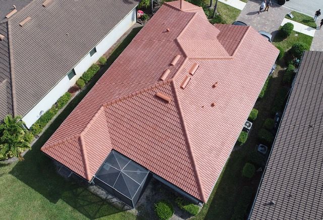 An aerial view of a house with a red tile roof