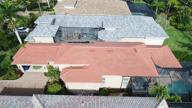 An aerial view of a large house with a red roof.