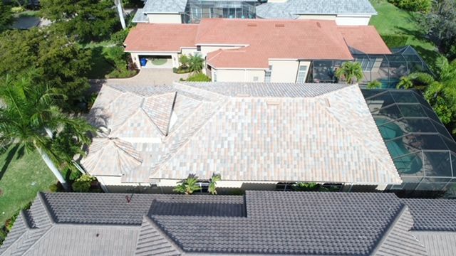 An aerial view of a large house with a roof and a pool.