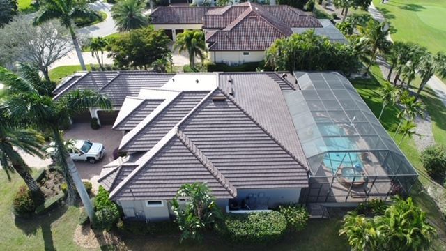 An aerial view of a house with a pool and a car parked in front of it.