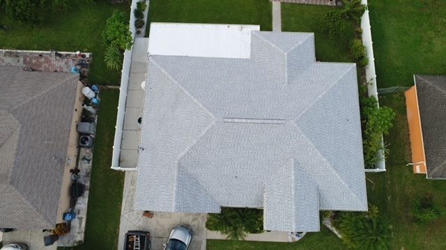 An aerial view of a house with a white roof.