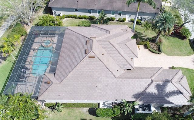 An aerial view of a house with a pool and a screened in porch.