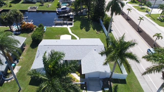 An aerial view of a house surrounded by palm trees