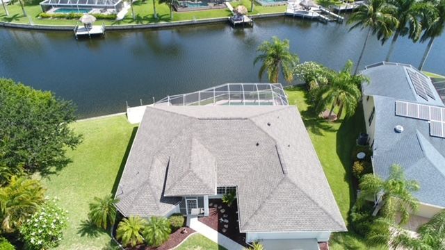 An aerial view of a house next to a body of water.