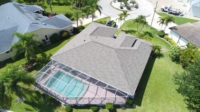 An aerial view of a house with a pool in the backyard.