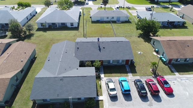 An aerial view of a residential area with cars parked in front of houses