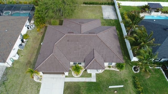 An aerial view of a house with a tiled roof and a pool.
