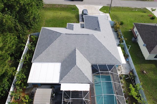 An aerial view of a house with a pool and a car parked in front of it.