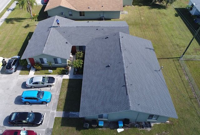 An aerial view of a row of houses with cars parked in front of them.