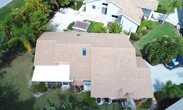An aerial view of a house with a roof that has a solar panel on it.