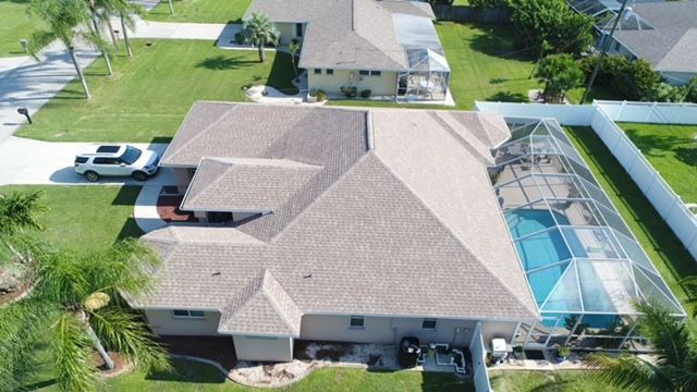 An aerial view of a house with a pool in the backyard.