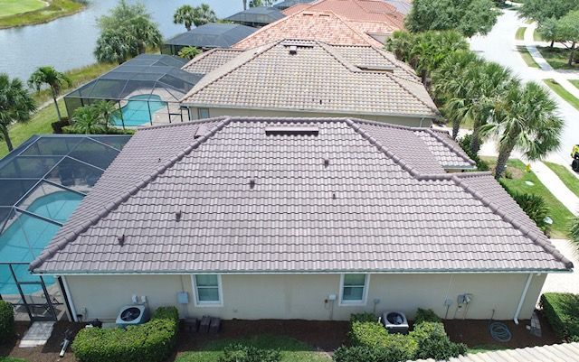 An aerial view of a house with a tiled roof and a pool.