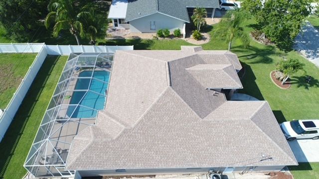 An aerial view of a house with a pool and a car parked in front of it.