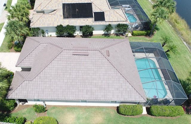 An aerial view of a house with a pool and solar panels on the roof.