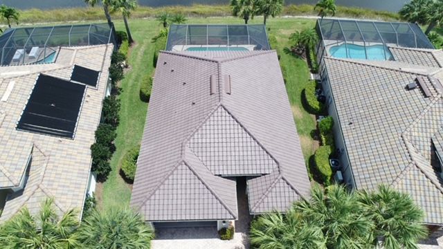 An aerial view of a house with a roof and a pool.