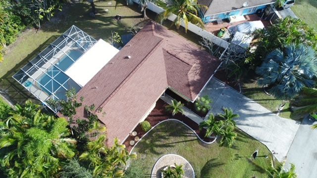 An aerial view of a house with a pool in the backyard
